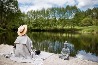 two people sitting on a dock near a body of water at Shanti Resort - Retreat & Wellness Center in Sarboriškės I