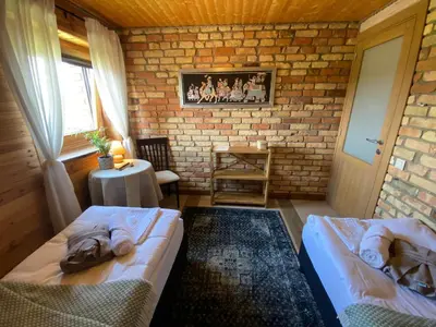 a bedroom with two beds and a brick wall at Shanti Resort - Retreat & Wellness Center in Sarboriškės I
