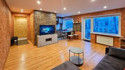 a living room with a couch and a tv at SunCity Apartment in Šiauliai