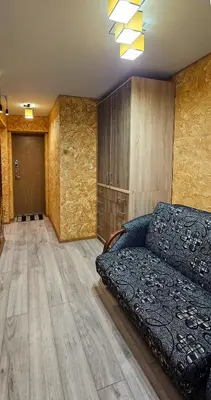 a living room with a couch and wooden floors at SunCity Apartment in Šiauliai