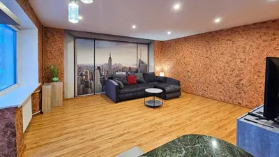 a living room with a couch and a large window at SunCity Apartment in Šiauliai