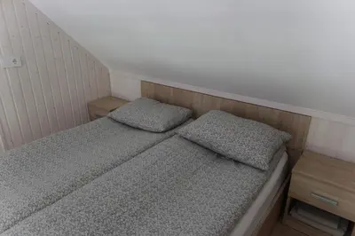 two beds in a small room with two pillows at Vila Pakaso malūnas in Kirdeikiai