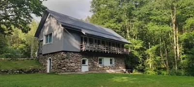 a stone house with a black roof at Vila Pakaso malūnas in Kirdeikiai