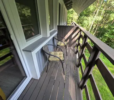 two chairs sitting on the porch of a house at Vila Pakaso malūnas in Kirdeikiai