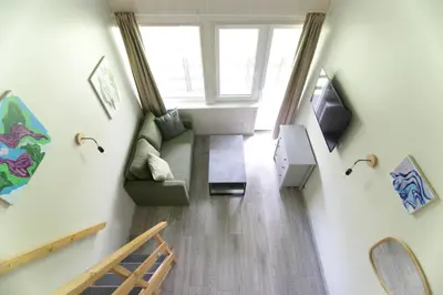 a living room with a couch and a television at Vila Pakaso malūnas in Kirdeikiai