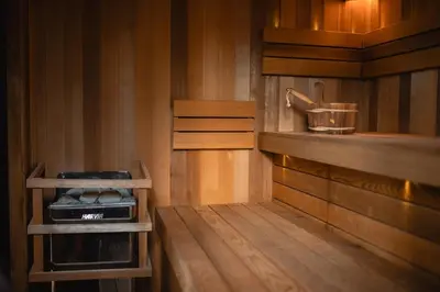 a small kitchen with wooden walls and wood floors at LAGUNA SPA šeimos poilsio namai in Geniai