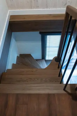 a staircase in a house with wooden floors and a window at LAGUNA SPA šeimos poilsio namai in Geniai