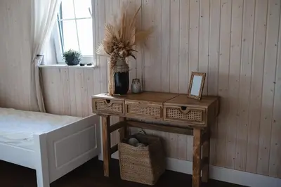 a wooden table with a mirror and a vase on it at LAGUNA SPA šeimos poilsio namai in Geniai