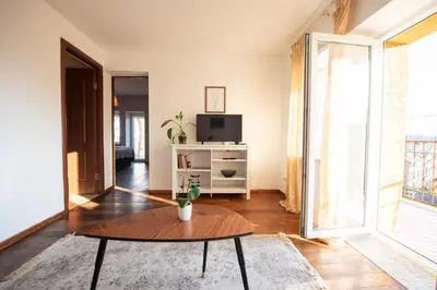 a living room with a table and a tv at Angelica Apartment in Vilnius
