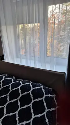a bedroom with a window and a black and white rug at Šiauliai Central Cozy Apartment in Šiauliai