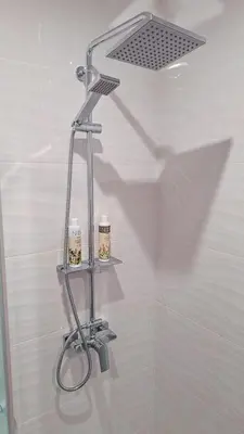 a shower shelf in a bathroom with two candles at Šiauliai Central Cozy Apartment in Šiauliai
