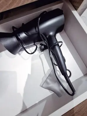 a black hair dryer in a white box at Šiauliai Central Cozy Apartment in Šiauliai