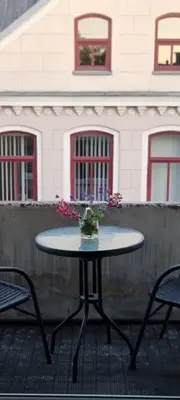 a table with a vase of flowers on it at city center apartment in Panevėžys