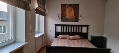 a bedroom with a bed with two pillows on it at city center apartment in Panevėžys
