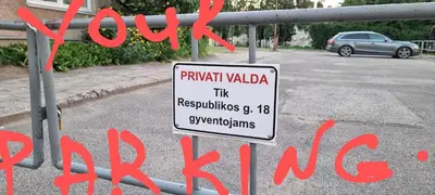 a sign on a metal fence in a street at city center apartment in Panevėžys