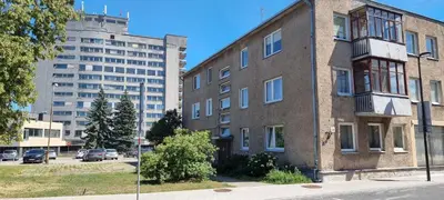 an old brick building next to a large building at city center apartment in Panevėžys