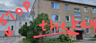 a brick building with a sign that says you are alive at city center apartment in Panevėžys
