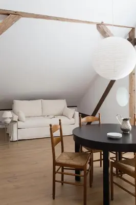 a living room with a white couch and a table at Aštriosios Kirsnos dvaras in Aštrioji Kirsna