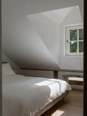 a bedroom with a white bed and a window at Aštriosios Kirsnos dvaras in Aštrioji Kirsna