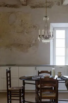 a dining room with a table and a chandelier at Aštriosios Kirsnos dvaras in Aštrioji Kirsna