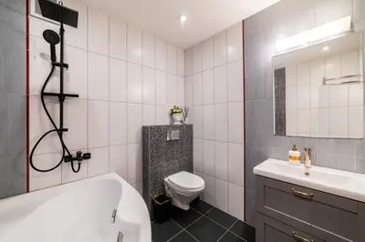 a bathroom with a tub and a toilet and a sink at ASTeS Apartments in Šiauliai