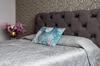 a bed with a blue pillow sitting on top of it at ASTeS Apartments in Šiauliai