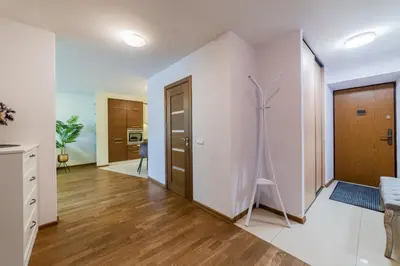a hallway with white walls and wooden floors at ASTeS Apartments in Šiauliai