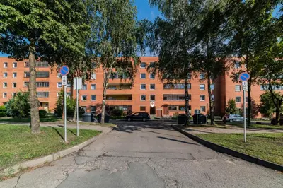 an empty street in front of a large brick building at ASTeS Apartments in Šiauliai
