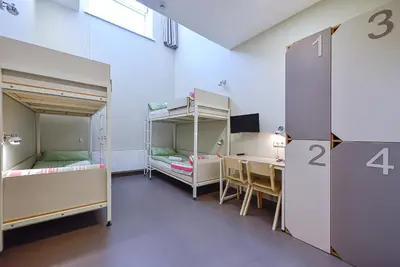 a room with two bunk beds and a desk at Nykščio Hostel in Anykščiai