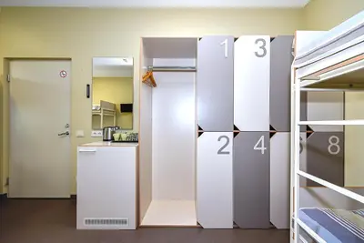 a room with a refrigerator and a door to a kitchen at Nykščio Hostel in Anykščiai