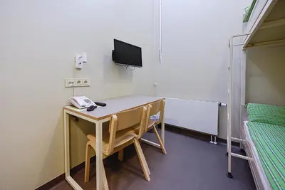 a room with a desk with a tv and a computer at Nykščio Hostel in Anykščiai