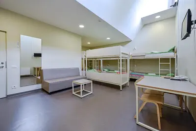 a room with two bunk beds and a table at Nykščio Hostel in Anykščiai