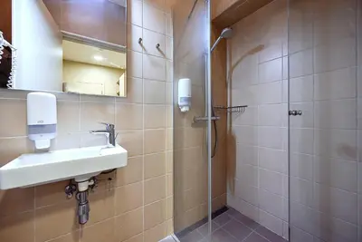 a bathroom with a sink and a shower at Nykščio Hostel in Anykščiai