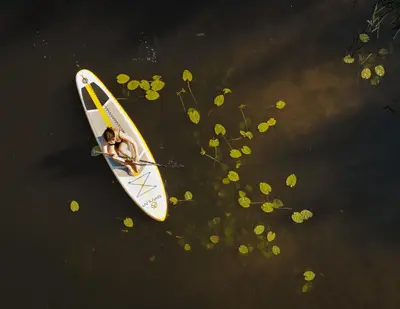 a person sitting on a surfboard in the water at Marga Pieva in Inturkė