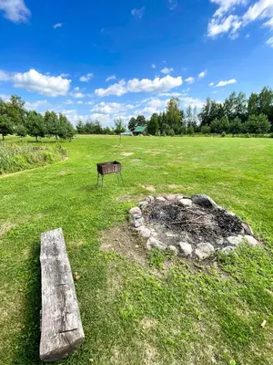 a bench sitting in a field with a fire pit at Marga Pieva in Inturkė