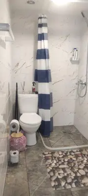 a bathroom with a toilet and a blue and white shower at Jolsva in Rokiškis
