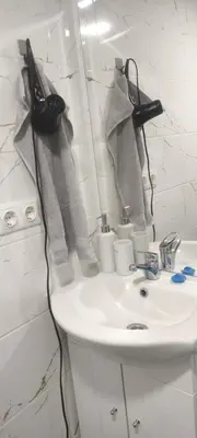 a bathroom sink with towels hanging on a wall at Jolsva in Rokiškis