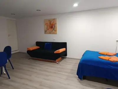 a bedroom with a bed and a couch and a chair at Jolsva in Rokiškis