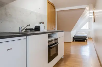 a kitchen with white cabinets and a sink at Fox studio mezzanine in Šiauliai