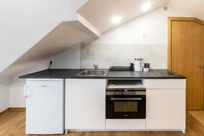 a kitchen with white cabinets and a sink at Fox studio mezzanine in Šiauliai