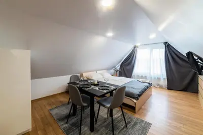 a bedroom with a bed and a table and chairs at Fox studio mezzanine in Šiauliai