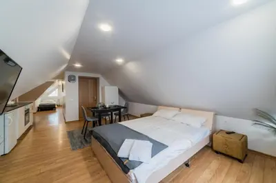 a bedroom with a large bed and a table at Fox studio mezzanine in Šiauliai