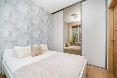 a bedroom with a white bed and a wall at Butukas dviems in Vilnius
