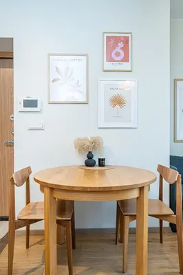 a wooden table and chairs in a room at Butukas dviems in Vilnius