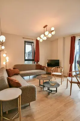 a living room with couches and tables and a tv at Stunning new flat in Old Town of Vilnius in Vilnius