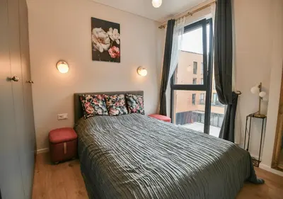 a bedroom with a bed and a large window at Stunning new flat in Old Town of Vilnius in Vilnius