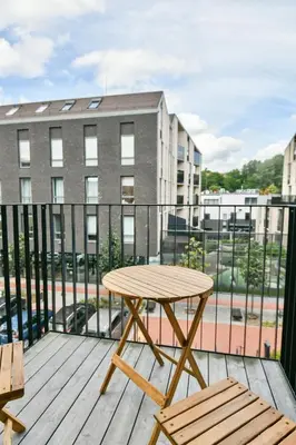 a wooden table and two chairs on a balcony at Stunning new flat in Old Town of Vilnius in Vilnius