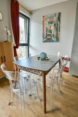 a dining room table with chairs and a painting on the wall at Stunning new flat in Old Town of Vilnius in Vilnius