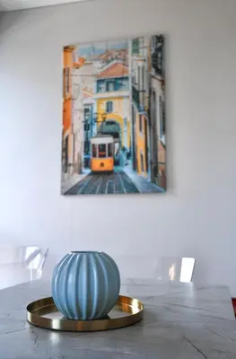 a vase sitting on a table in front of a painting at Stunning new flat in Old Town of Vilnius in Vilnius