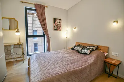 a bedroom with a bed and a large window at Stunning new flat in Old Town of Vilnius in Vilnius